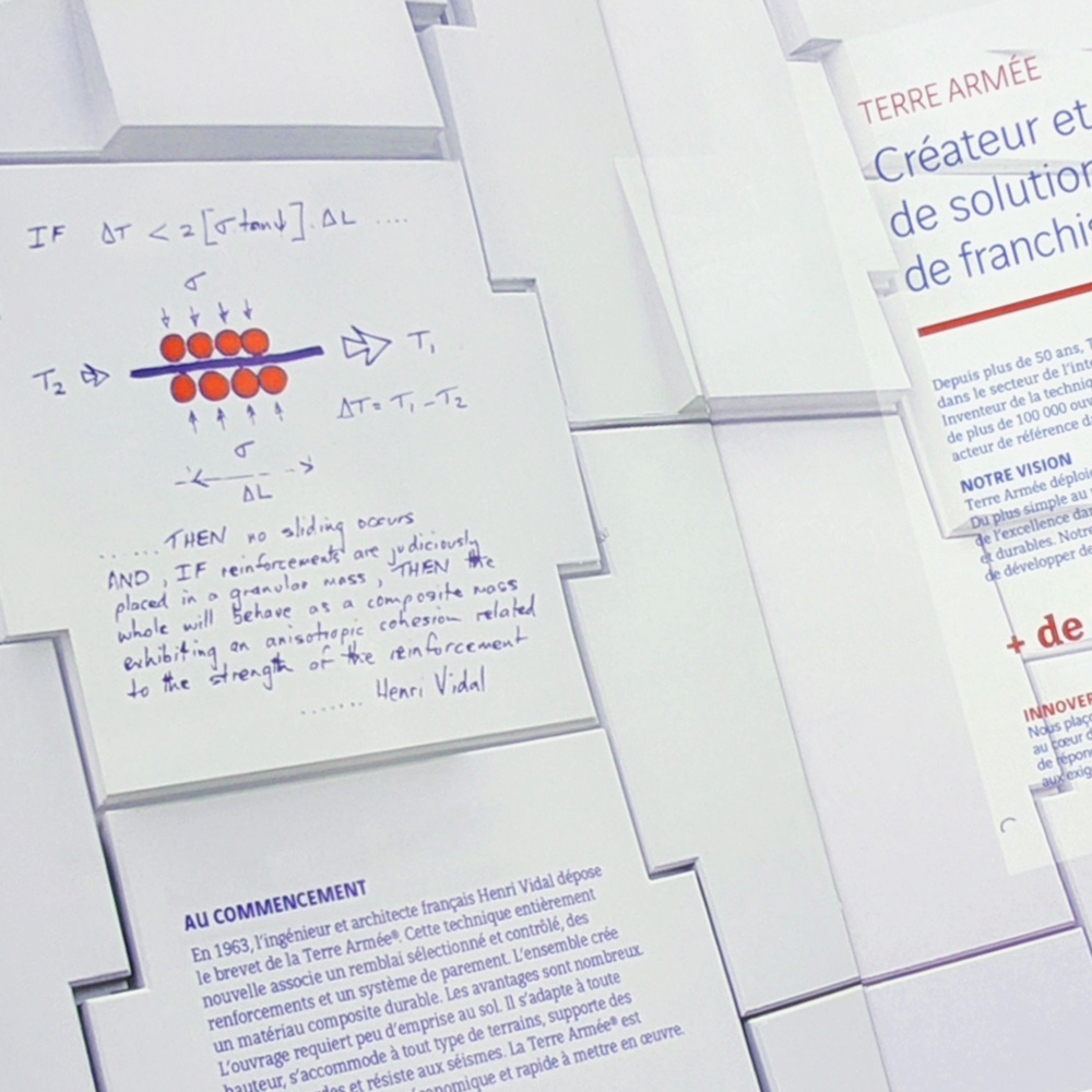 Zoom sur l’intérieur de la brochure, le paterne vue en gros plan, des notes et schéma à la main sur une des tuiles du fond.