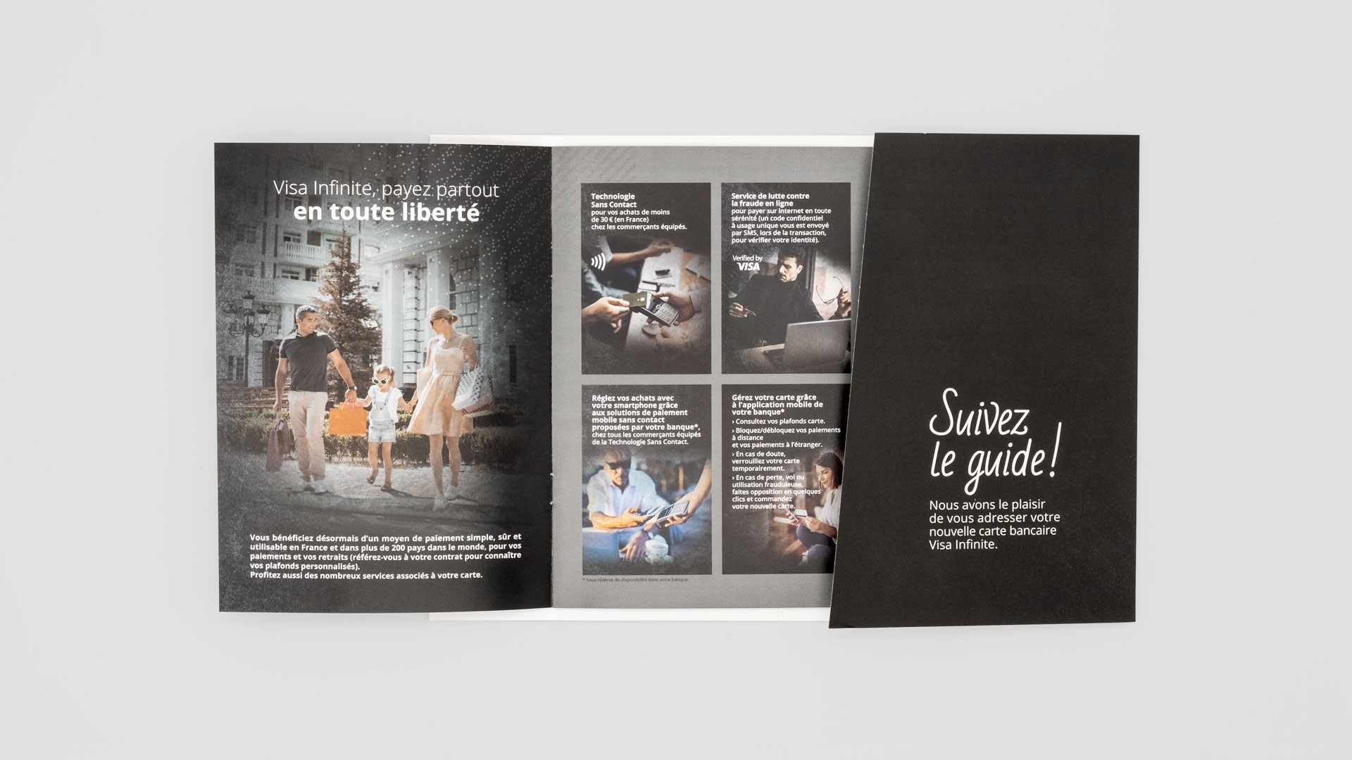 Pochette noire du welcome pack présentant le guide d'utilisation Visa Infinite ouvert sur une double page