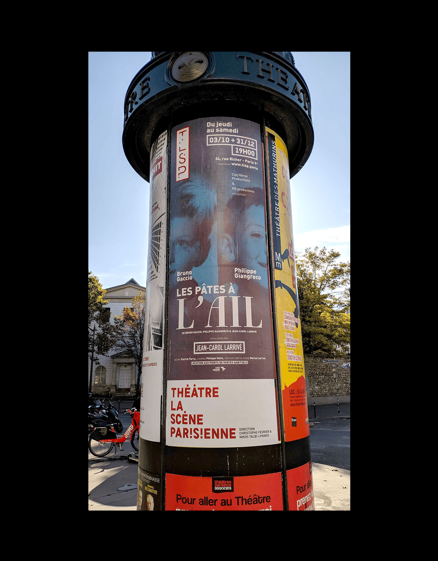 Photo in situ d’une colonne Maurice dans une rue de Paris, l’affiche « Les Pâtes à l’ail » est collé dessus.