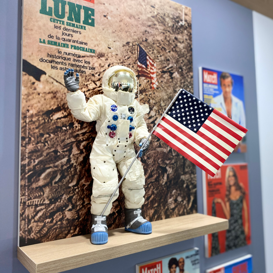 Une figurine de Neil Armstrong en scaphandre blanc tenant le drapeau américain : c’est le premier homme sur la lune. Derrière, la couverture du « Paris Match » de l’époque rappelle cet événement historique du 21 juillet 1969.