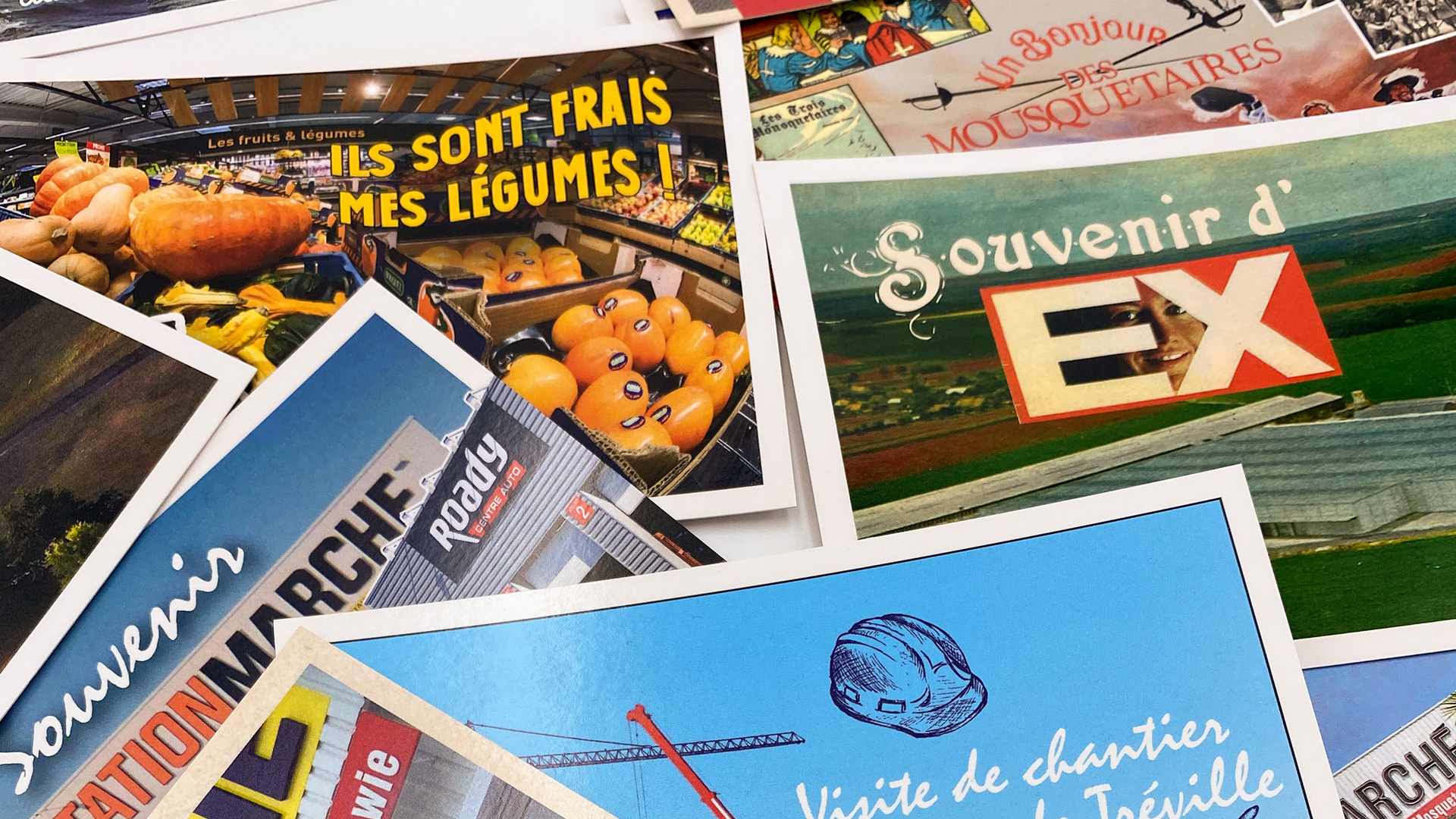 Vue des cartes postales réalisées pour promouvoir le lieu. Cet hommage aux cartes postales de vacance kitsch est glissé au hasard dans les boîtages.